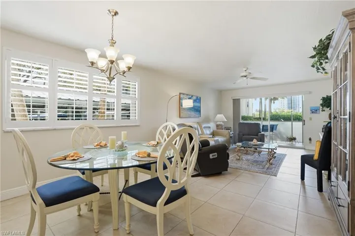 Dining space featuring a ceiling fan, light tile patterned floors, and a chandelier