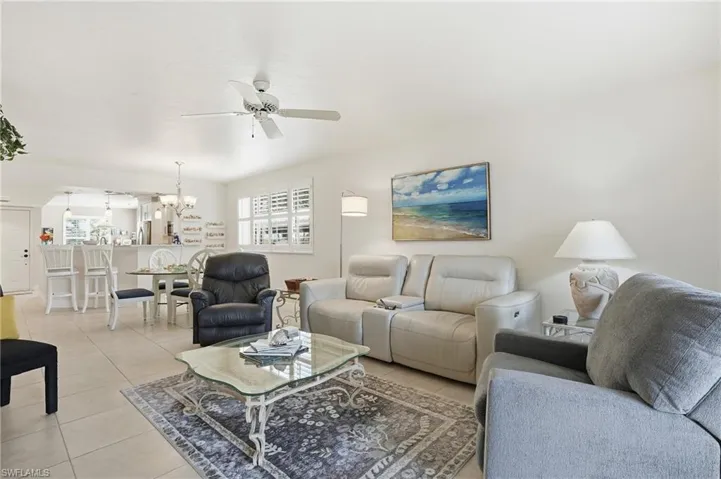 Living area with light tile patterned floors, ceiling fan, and suspended lighting