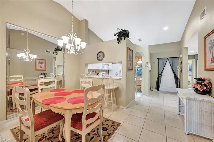 Dining space with arched walkways, light tile patterned floors, high vaulted ceiling, and recessed lighting