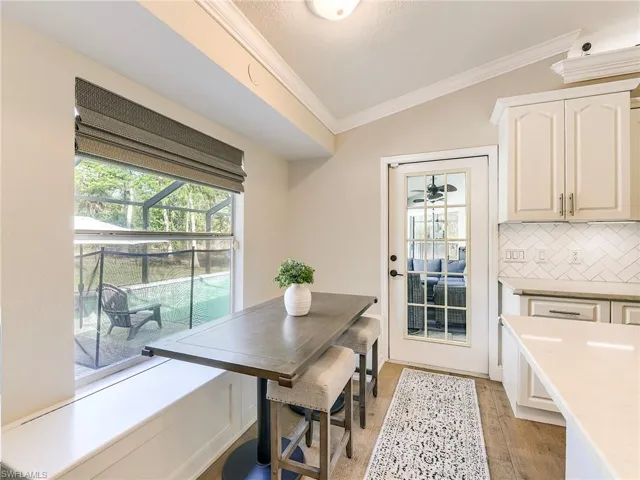 Dining space featuring ornamental molding, lofted ceiling, and light wood-style floors