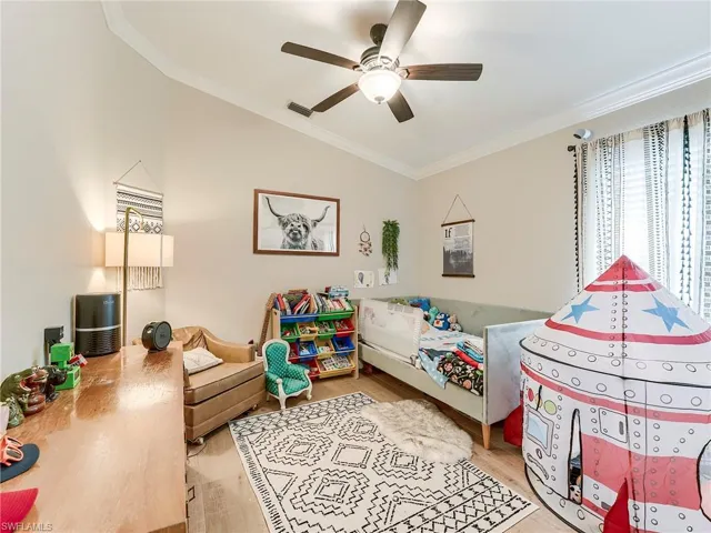 Bedroom 3 with ornamental molding, light wood finished floors, a ceiling fan, and vaulted ceiling