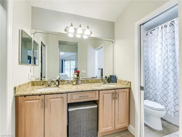Bathroom featuring double vanity and a shower with curtain
