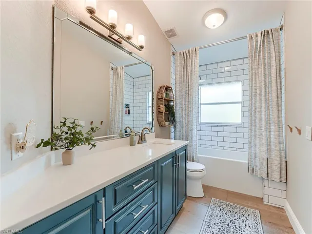 Second Bathroom with vanity, shower / bath combo, and light wood-style floors