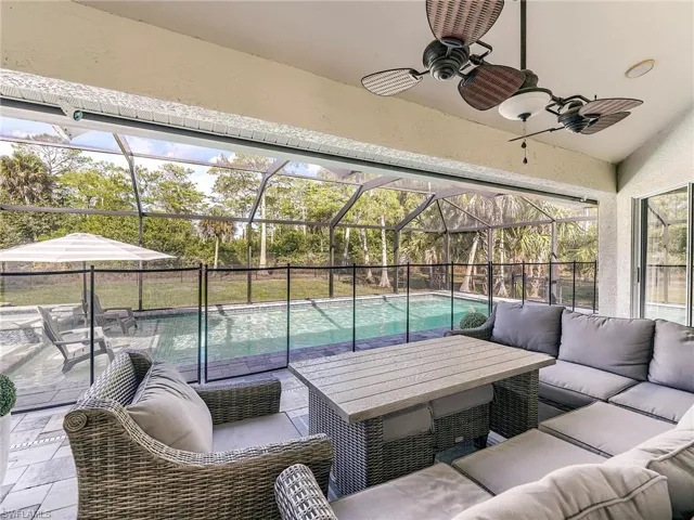 View of patio / terrace with outdoor lounge area, a sunroom, ceiling fan, and glass enclosure