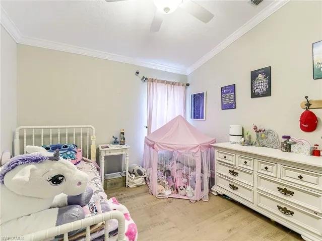 Bedroom 2 featuring crown molding, a ceiling fan, light wood-style flooring, and a textured ceiling