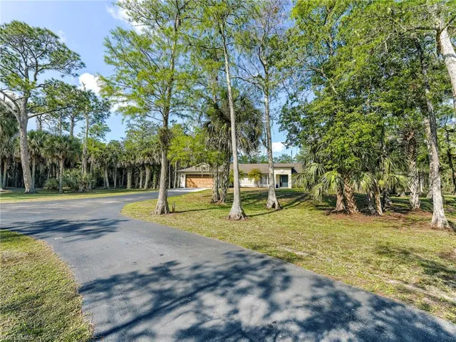 View of front of home featuring a front lawn, asphalt driveway, and a garage