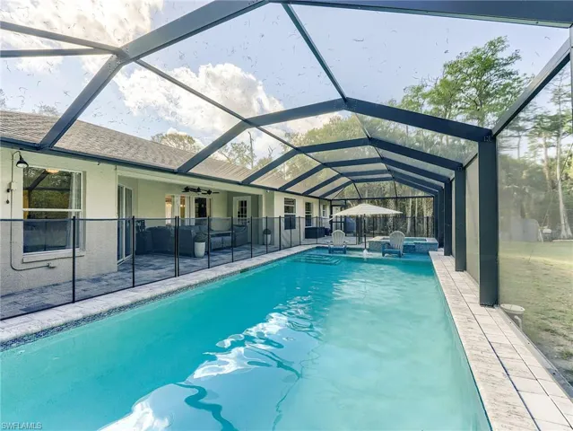 Swimming pool with a sunroom, a lanai, and a patio