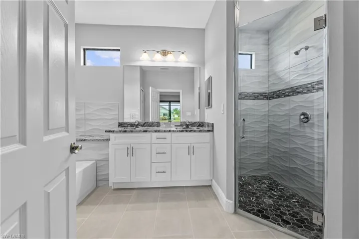 Bathroom with separate shower and tub, dual sinks, tile floors, and oversized vanity