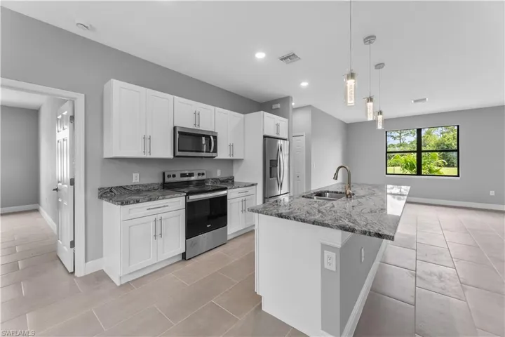 Kitchen with white cabinetry, sink, a kitchen island with sink, and stainless steel appliances