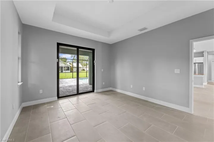 Tiled spare room with a raised ceiling