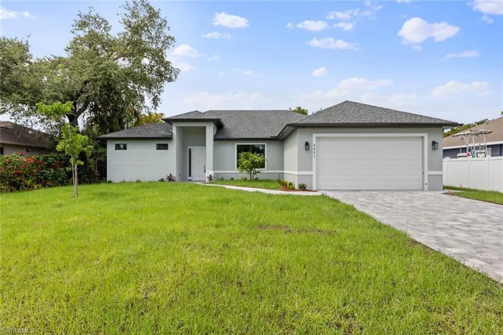 View of front of home with a garage and a front yard