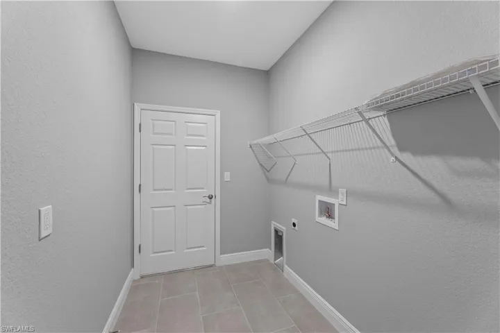 Laundry area with washer hookup, light tile flooring, and electric dryer hookup