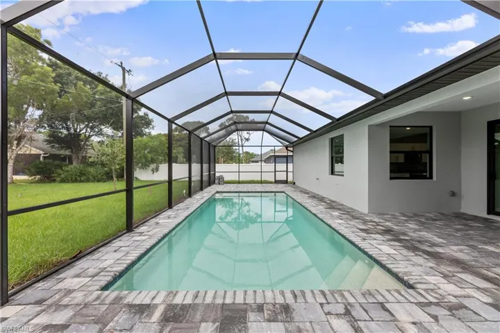 View of swimming pool with a lanai, a patio area, and a yard