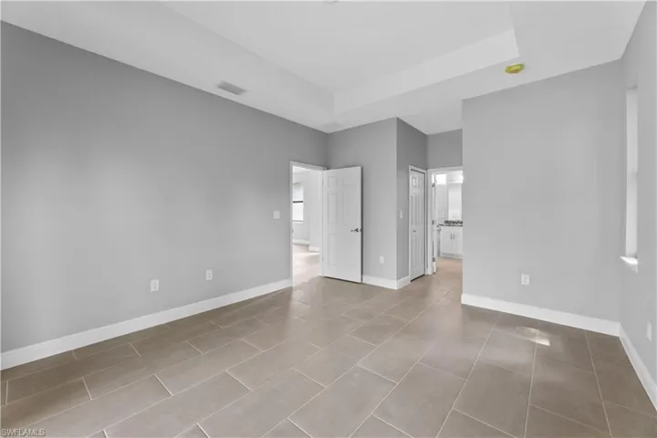 Unfurnished room with a raised ceiling and tile flooring