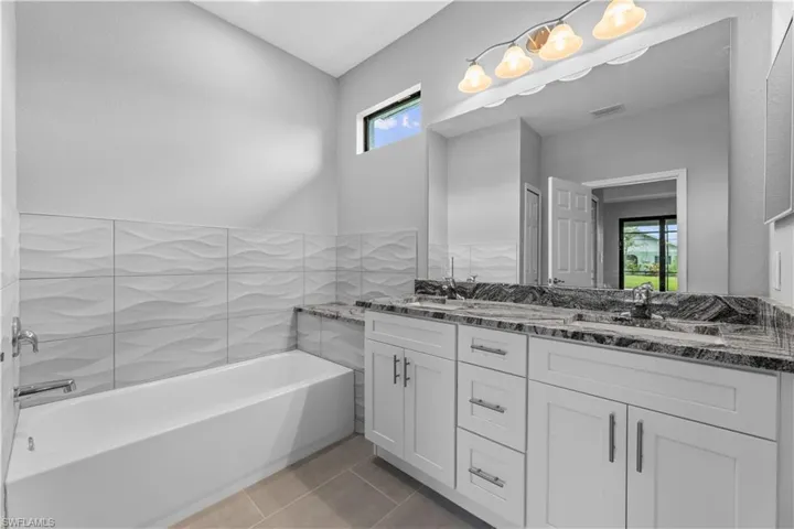 Bathroom with dual vanity and tile flooring