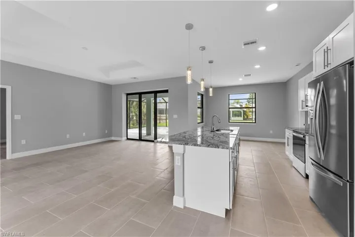 Kitchen with plenty of natural light, sink, white cabinetry, and appliances with stainless steel finishes