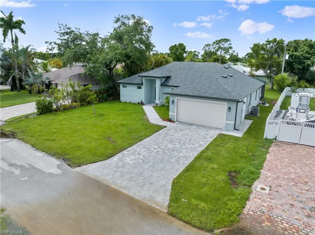 View of front of house featuring a garage and a front lawn