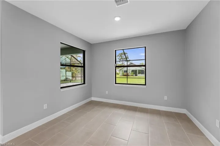 Unfurnished room featuring a healthy amount of sunlight and light tile floors
