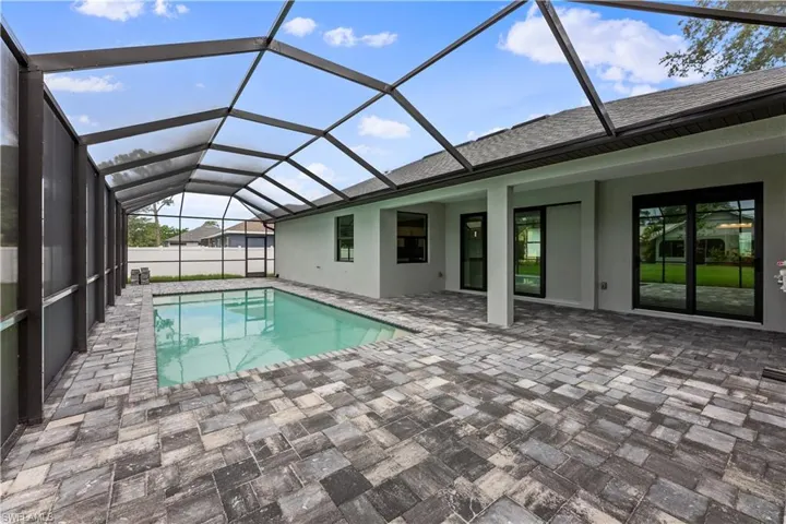View of swimming pool with a patio area and a lanai