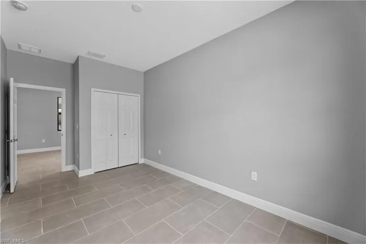 Unfurnished bedroom featuring a closet and light tile flooring
