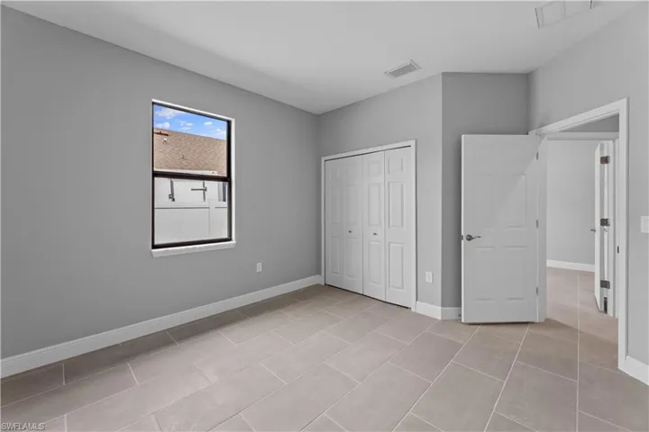 Unfurnished bedroom featuring a closet and light tile floors