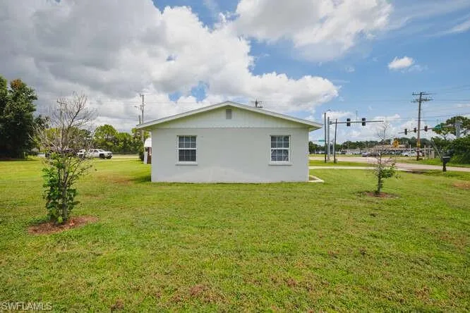 View of side of home featuring a lawn and stucco siding