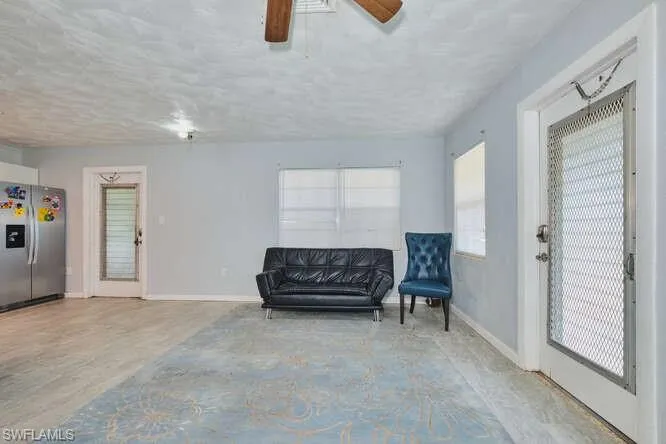 Living area with baseboards and ceiling fan