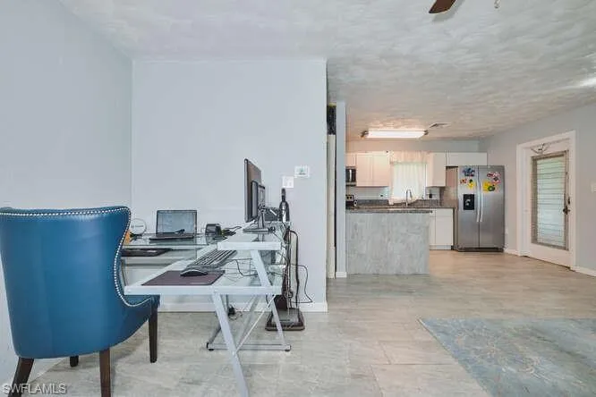 Office featuring ceiling fan and a textured ceiling