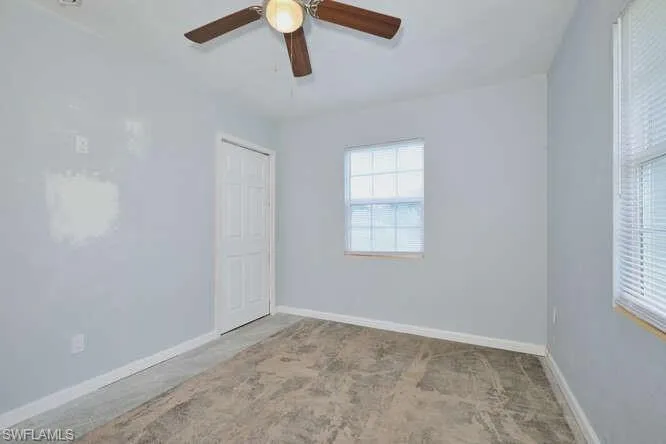 Spare room featuring baseboards and ceiling fan