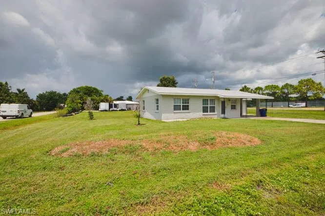 View of front of house with a front yard and a carport