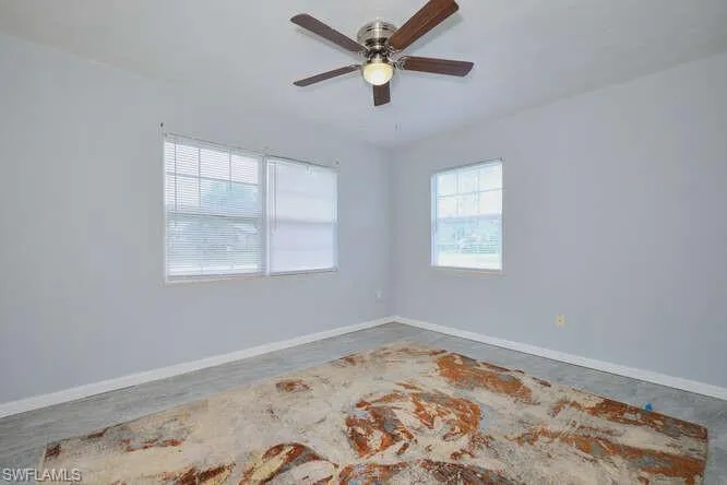 Unfurnished room featuring baseboards and ceiling fan