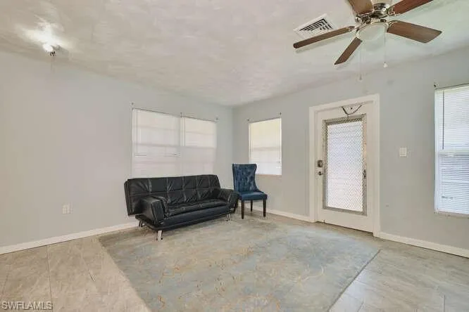 Sitting room featuring plenty of natural light, a ceiling fan, and light tile patterned floors