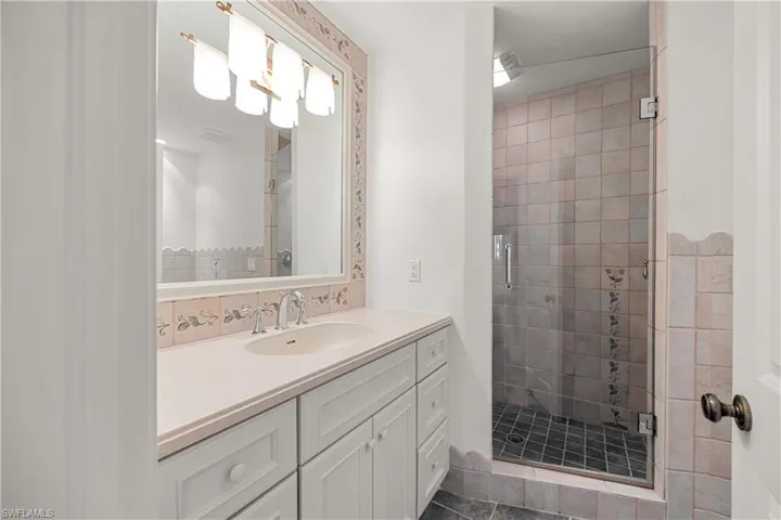 Bathroom featuring vanity, tile patterned floors, and a shower with door