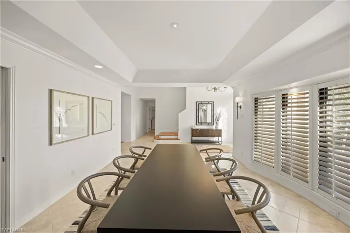 Dining room featuring light tile patterned floors and crown molding