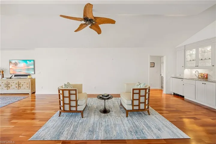 Living area featuring ceiling fan, light wood-type flooring, sink, and high vaulted ceiling