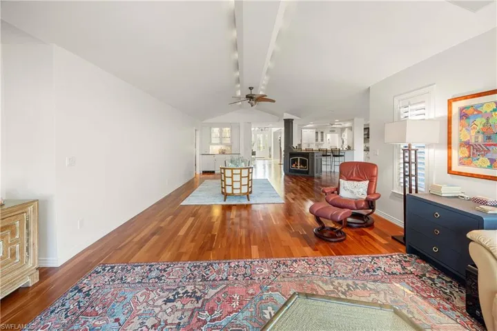 Living room with ceiling fan, hardwood / wood-style floors, and lofted ceiling
