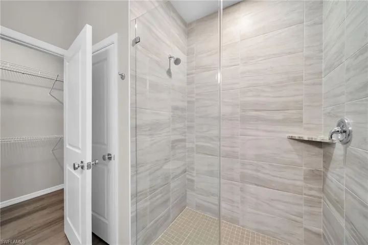 Bathroom with wood-type flooring and a shower with door