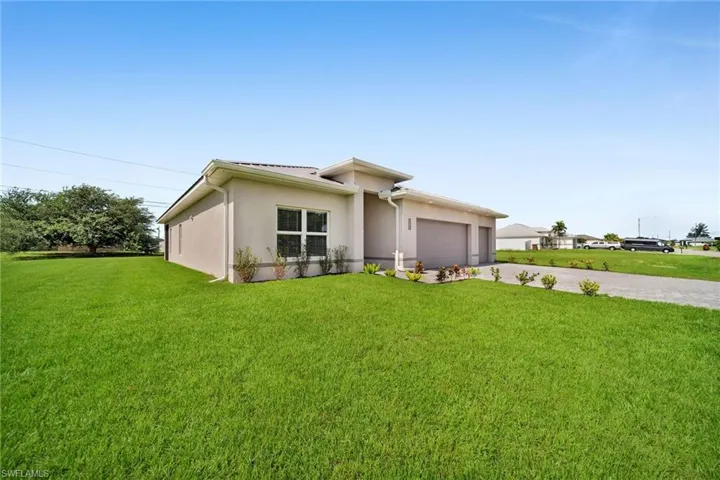 View of front of home with a front yard and a garage