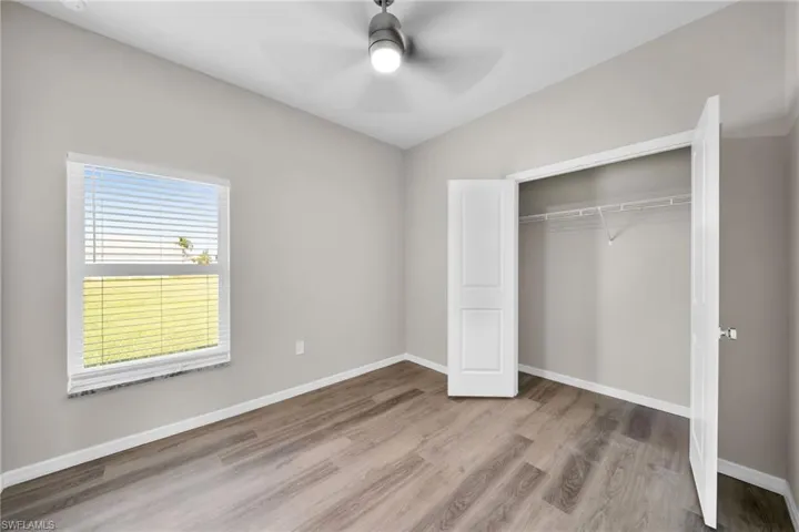Unfurnished bedroom featuring ceiling fan, a closet, and light hardwood / wood-style flooring