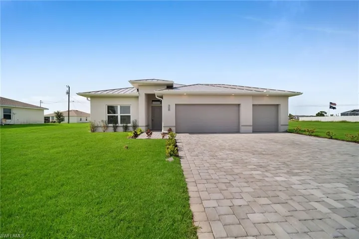 View of front of house featuring a garage and a front lawn