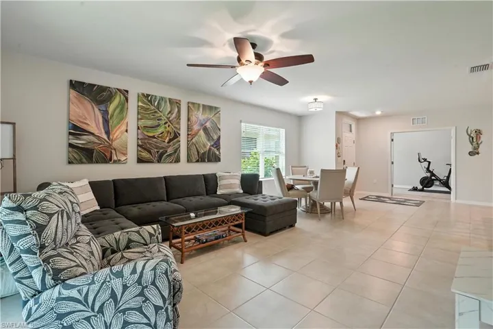 Living room featuring light tile patterned floors and a ceiling fan