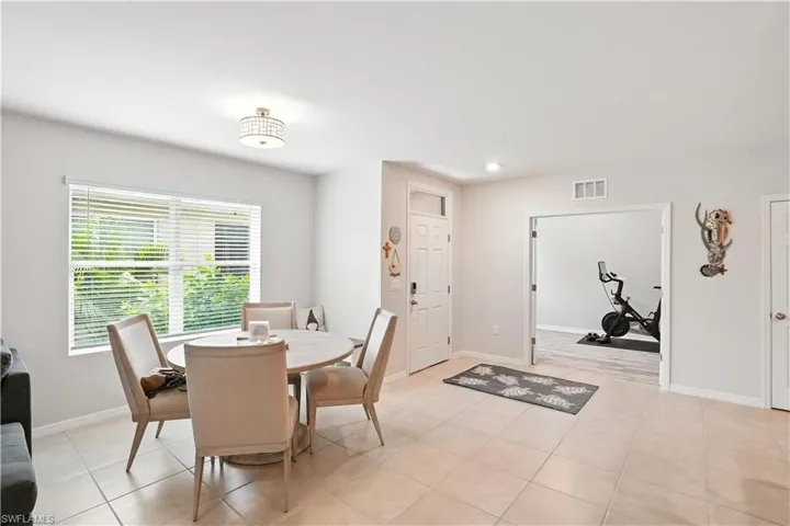 Living area featuring a ceiling fan and light tile patterned floors