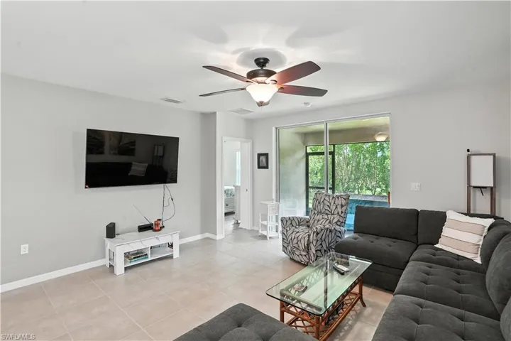 Living room with light tile patterned floors and ceiling fan