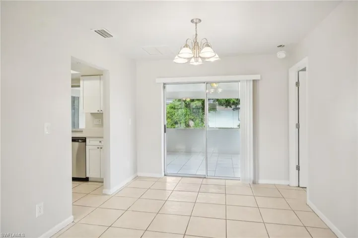 Unfurnished room featuring a chandelier and light tile patterned floors