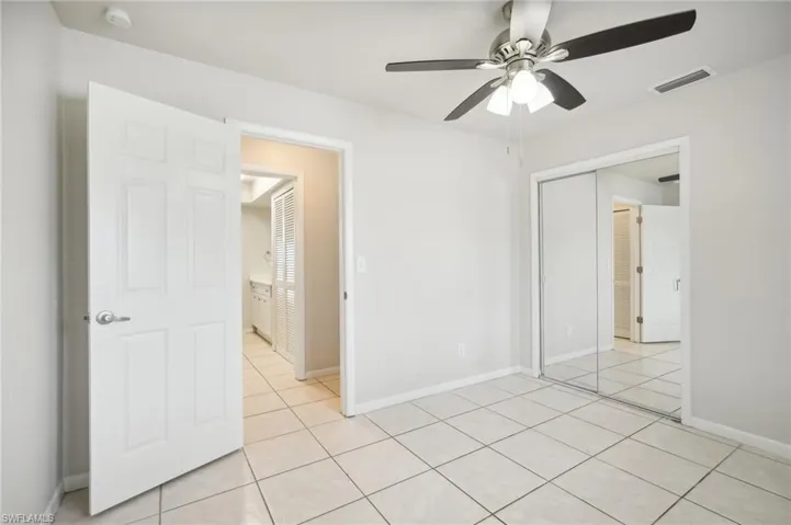 Tiled spare room with ceiling fan