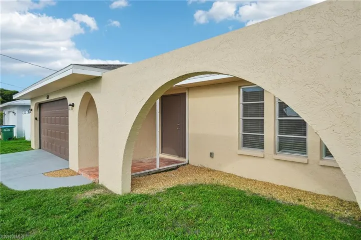 Back of property featuring a garage and a yard