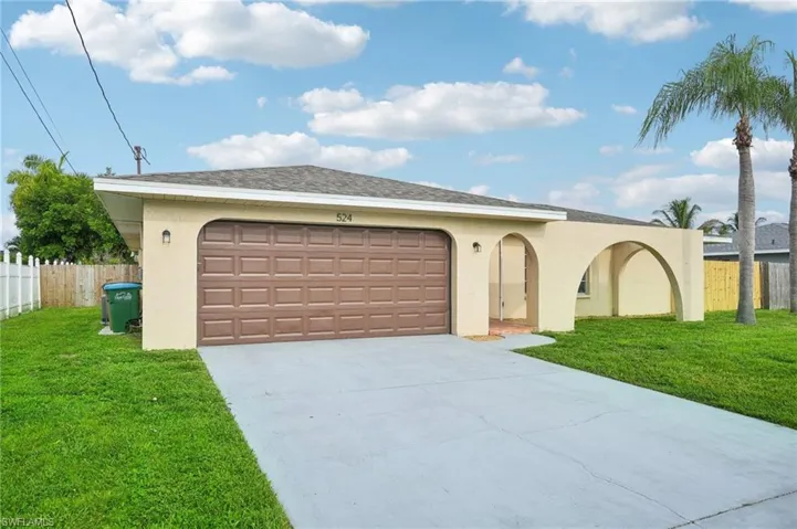 Ranch-style house featuring a garage and a front lawn