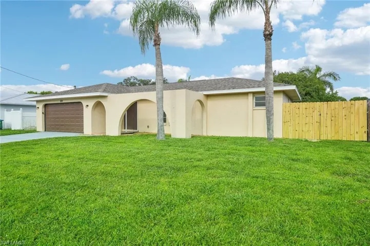Ranch-style home with a garage and a front lawn