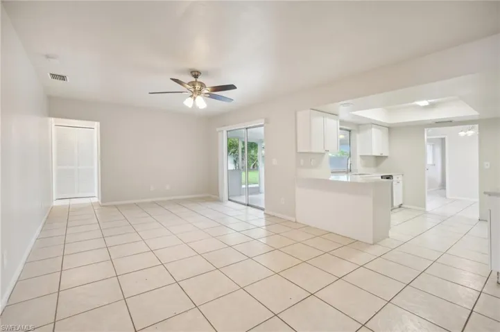 Spare room featuring light tile patterned flooring, a tray ceiling, and ceiling fan