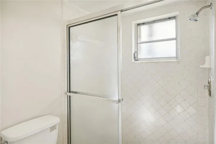 Bathroom featuring an enclosed shower and toilet